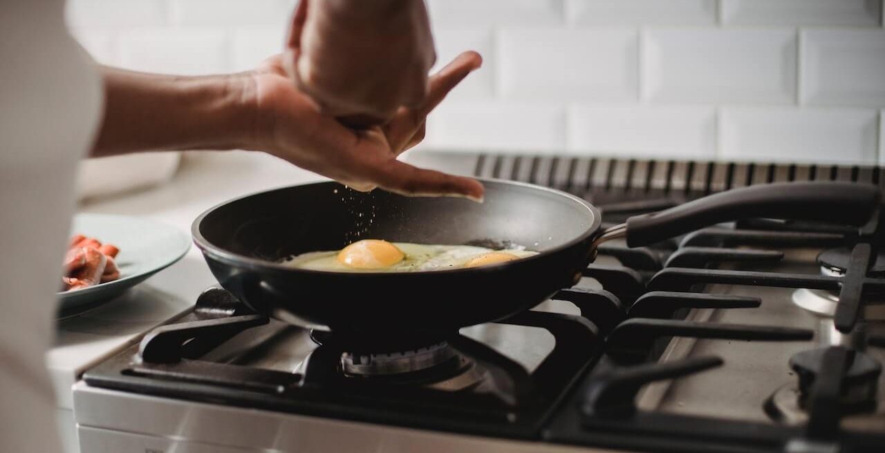 La photo d'une personne faisant frire un œuf